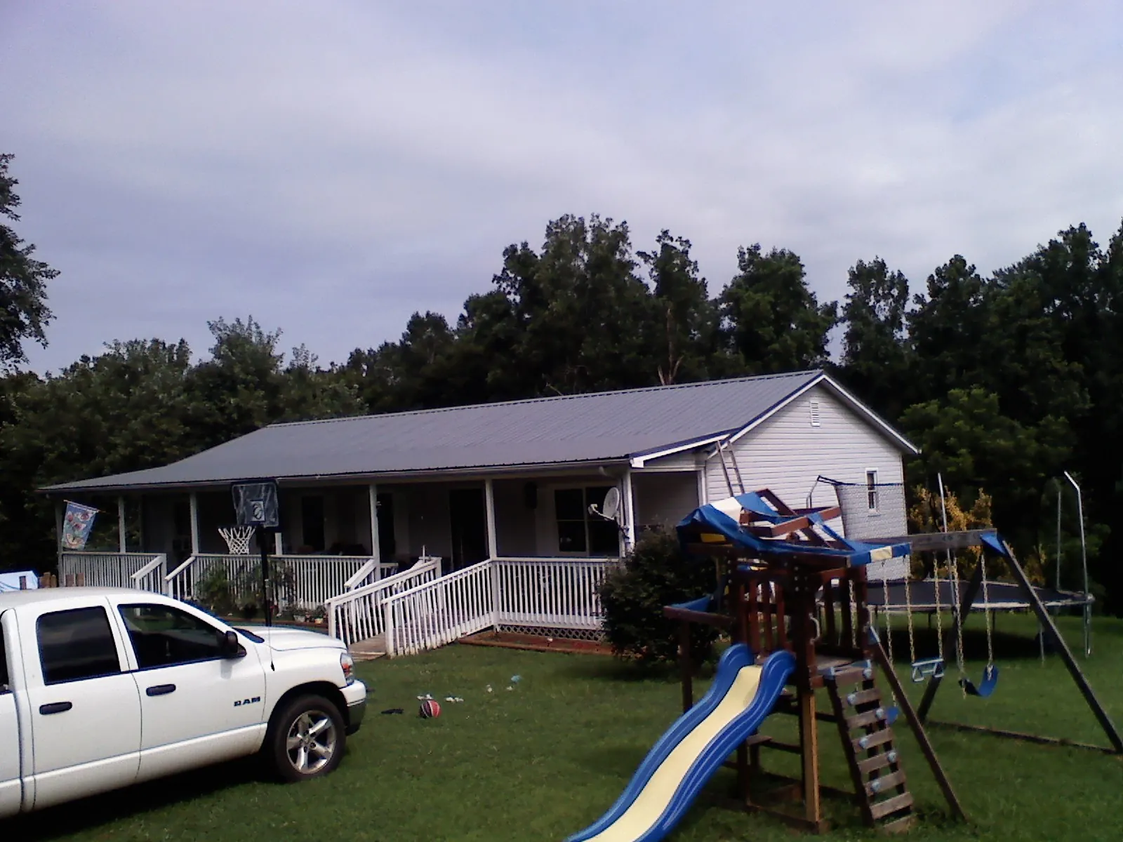 Dark metal roof on a country home with a full length front porch in Spangler
