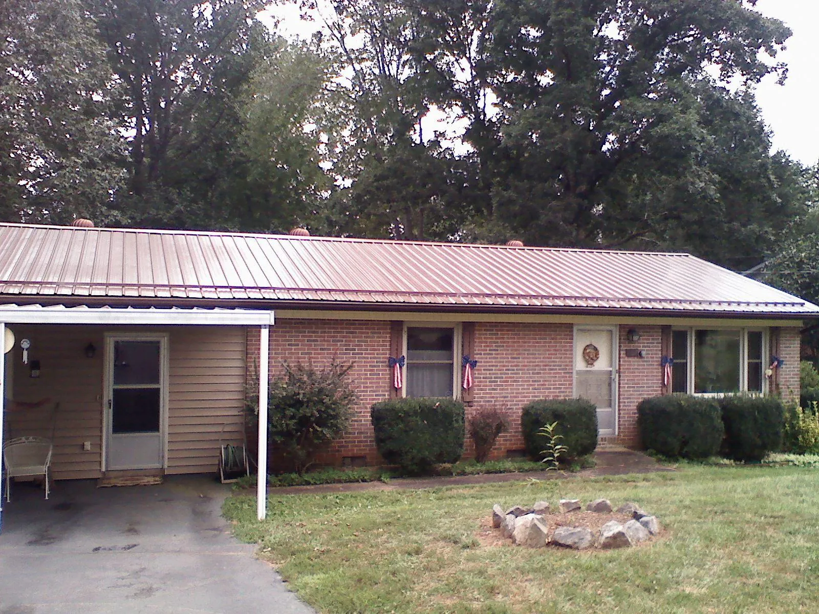 Bronze metal roof and carport on a brick ranch home — Roof Repair work by our crew in Spangler