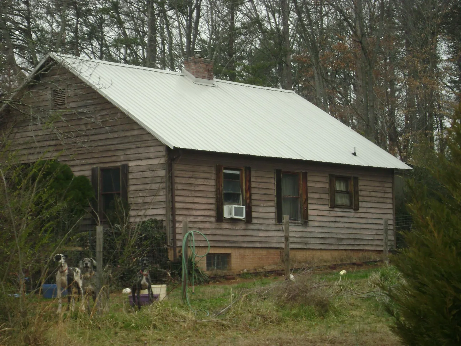 White metal roof on an old wood sided farmhouse, from a Metal Roof Installation job in Spangler
